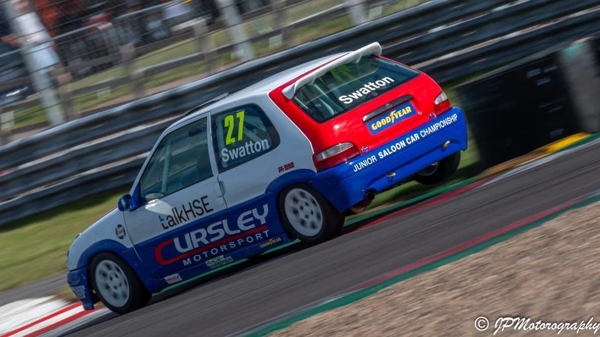 Matthew Swatton's race car on two wheels navigating the Goddards chicane at Donington Park national circuit